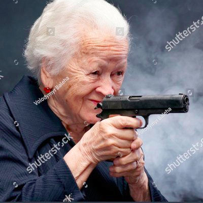 Stock image of an old lady holding up a gun and smiling