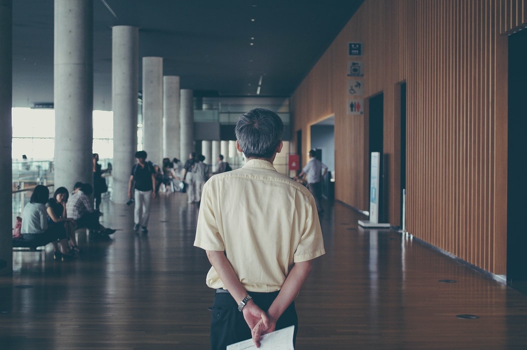 Back of an old professor holding papers